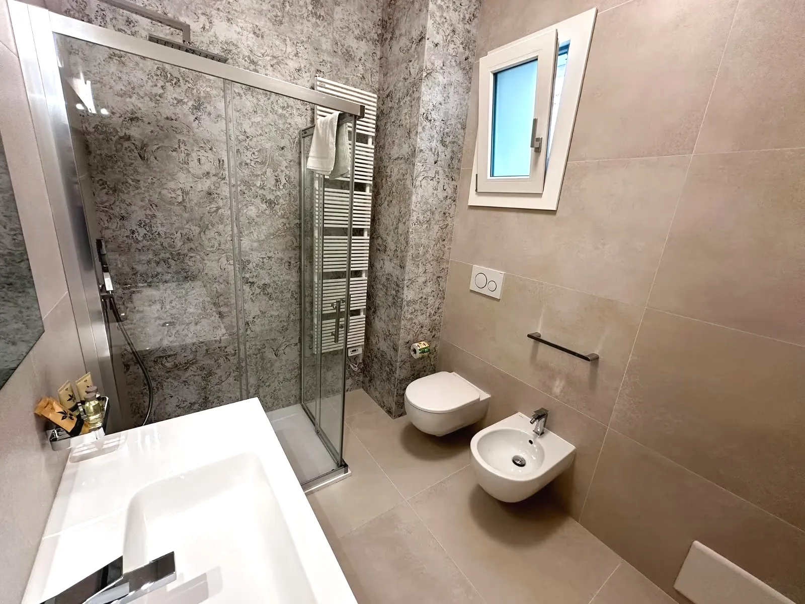 Bagno con doccia in finitura effetto pietra, appartamento Borea Otranto